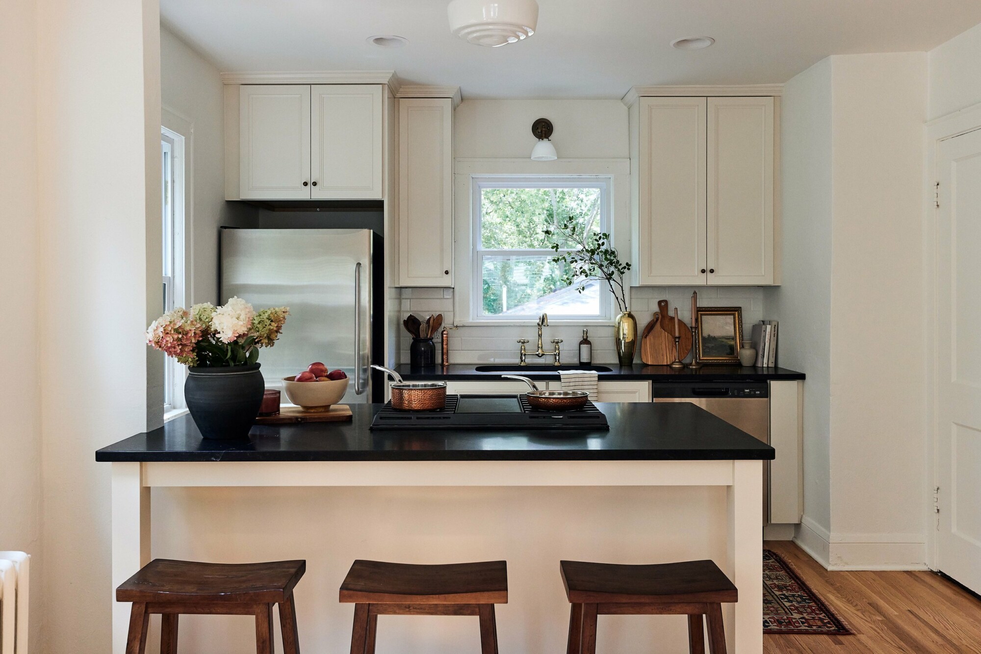 Our stucco farmhouse rental property renovation - kitchen layout & design reveal; cream cabinet island with honed black granite counters