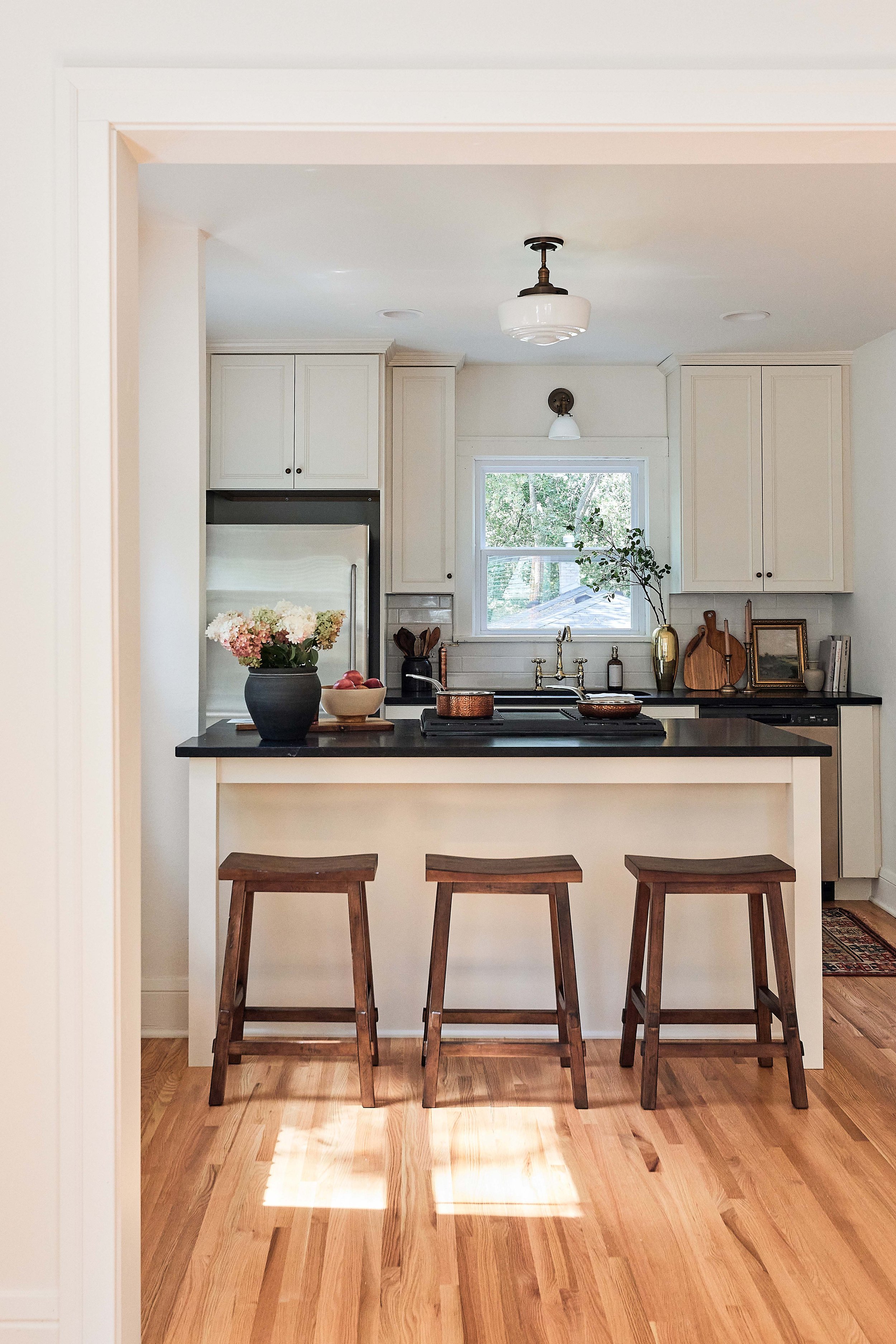 Our stucco farmhouse rental property renovation - kitchen layout & design reveal; cream cabinet island with honed black granite counters